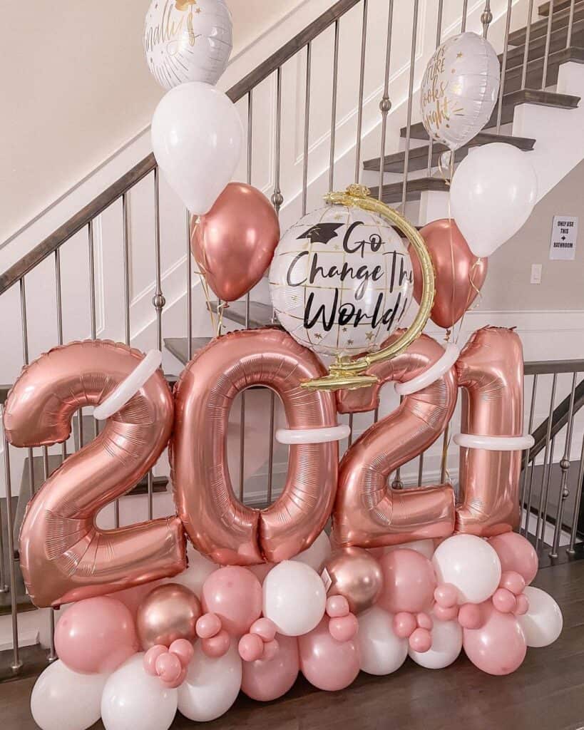 rose gold and white graduation balloons consists of graduation year, graduation world globe, and balloons.