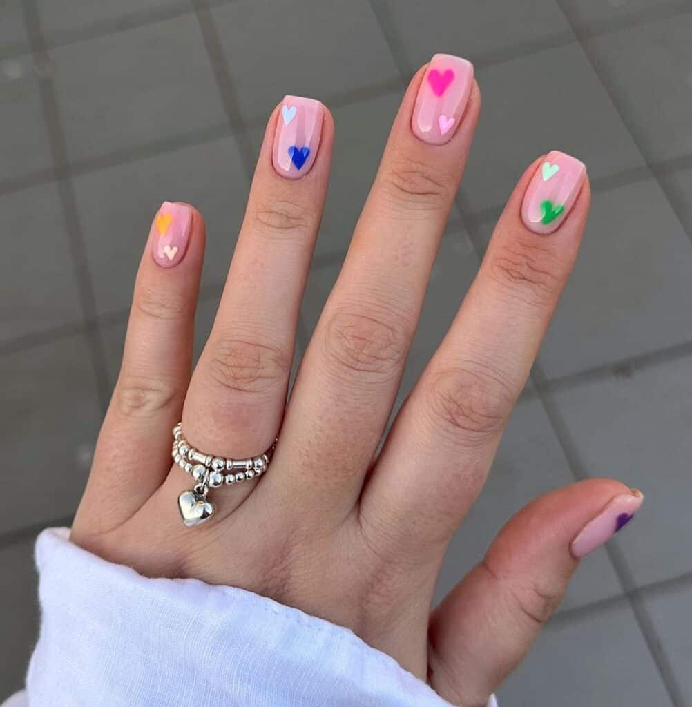 Pink based gel nails with mini colored hearts